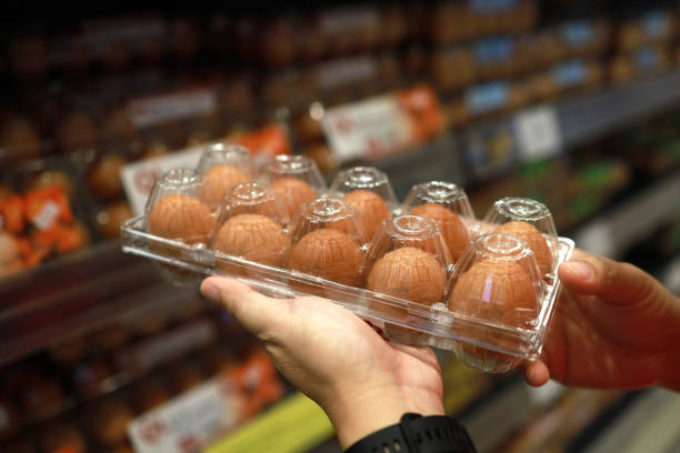 Customer buys chicken eggs in grocery store stock photo