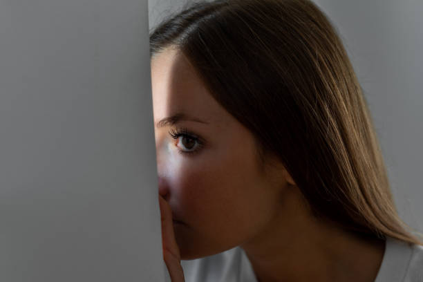 Woman scared looking through the window seeking safety