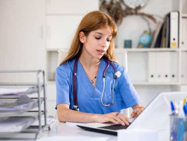 istock Woman doctor sitting at workplace with computer in her office 1435233591