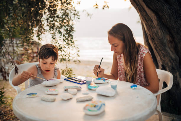 istock Mother and daughter enjoy spending time together, drawing on rocks 1435235107