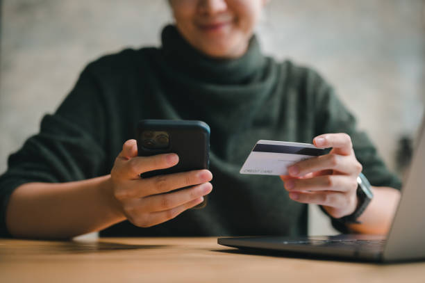 オンラインショッピングとeコマースのコンセプト、スマートフォンを使った幸せな笑顔の女性の手、自宅でオンラインでの買い物支払い用のクレジットカードを持つ。 - オンラインショッピング ストックフォトと画像