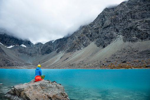 Woman enjoys  Blaisvatnet, blue lake is a popular hiking destination, with mountains of the Lyngen Alps, Lyngenfjord, Troms og Finnmark, Norway
