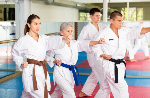istock Group lesson in karate or taekwondo in gym. Practicing blows 1435240351
