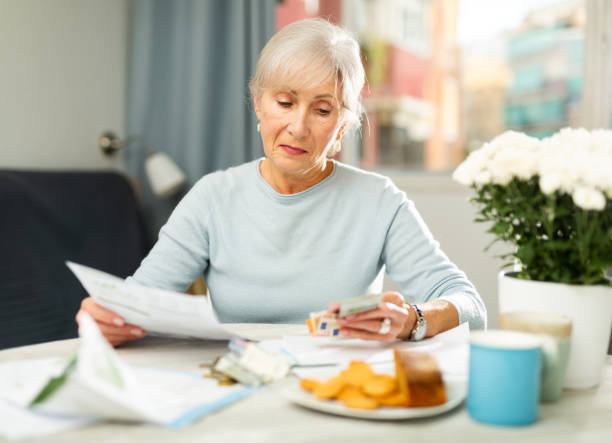 istock Senior woman with financial documents at home 1435240658
