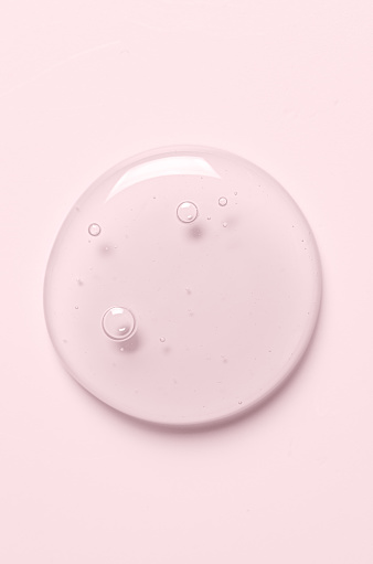 Pink drops of gel closeup. Cosmetic product for moisturizing the skin of the face or body