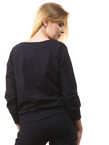 View from back on young blonde woman wearing black top outfit. Female being fashionable.