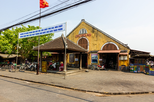 Hoi An, Vietnam - April 2016: The exterior facade of the historic Hoi An market building with yellow walls in the old quarter of the town.