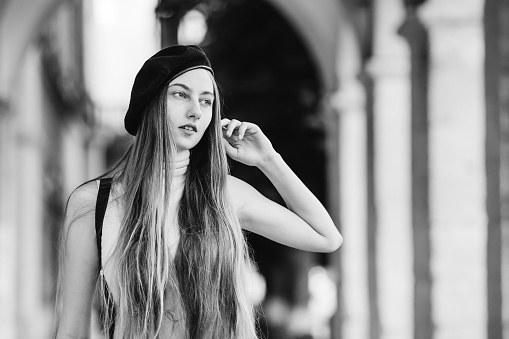 girl with black beret and long hair looks distant on black and white photography