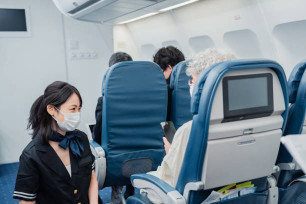 istock Flight attendant serving a passenger wearing a mask 1435251477