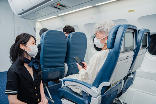 Flight attendant serving a passenger wearing a mask