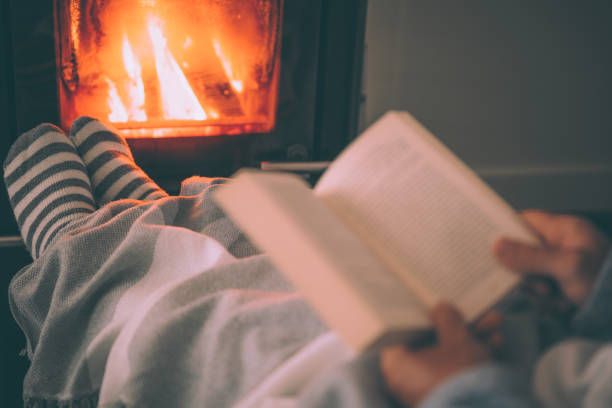 istock Man resting with book near fireplace 1435251966
