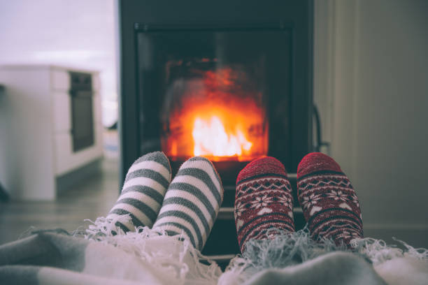 istock Feet woollen socks by fireplace 1435251984