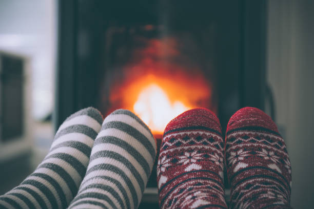 istock Feet woollen socks by fireplace 1435251999