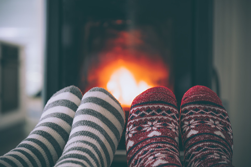 Feet woollen socks by christmas fireplace
