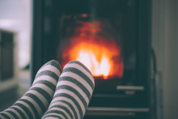istock Feet woollen socks by fireplace 1435252016