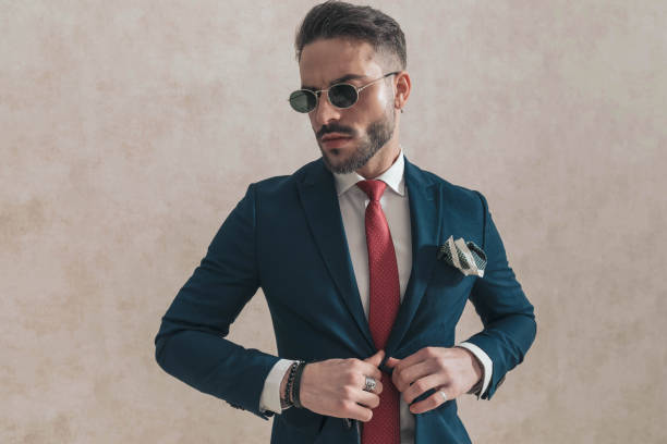 istock sexy young guy with sunglasses adjusting and opening navy blue suit 1435254234