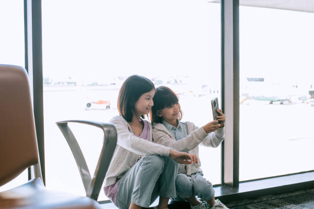 asiatische chinesische mädchen telefonieren am flughafen - stargate stock-fotos und bilder