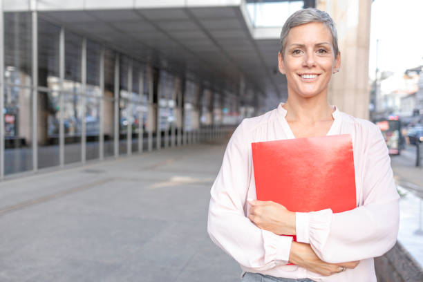 istock Business woman holding document folder in her arms 1435257883