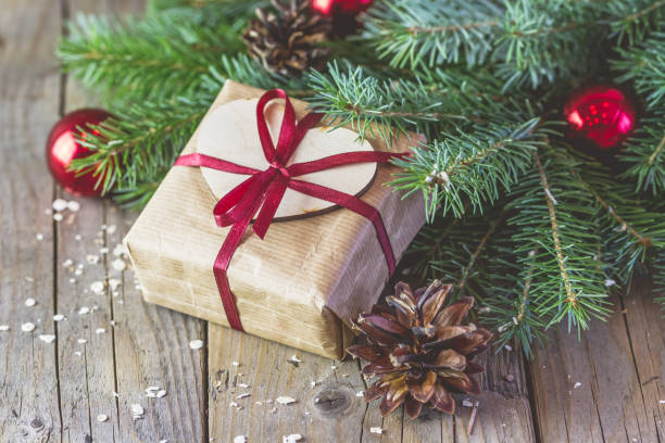 istock Gift box decorated red ribbon with bow and fur-tree branches 1435261226