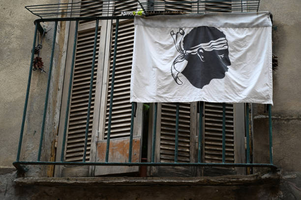 Corsican flag Corsican flag with its Moor's head hanging on the balcony of a dwelling corsican flag stock pictures, royalty-free photos & images