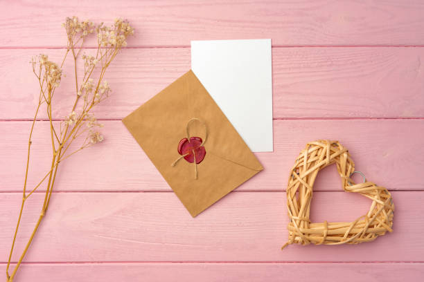 istock Envelope with letter on pink wooden background top view 1435261859