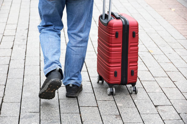 Male legs and luggage on autumn street, travel concept