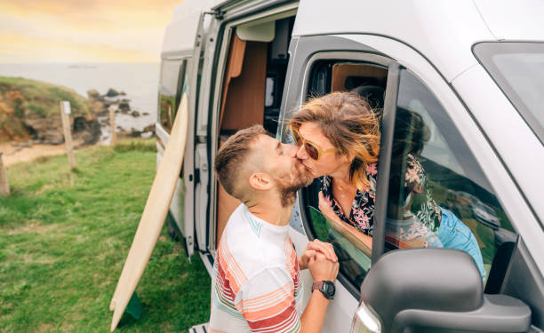 istock Couple kissing through the camper van window during a trip 1435264831