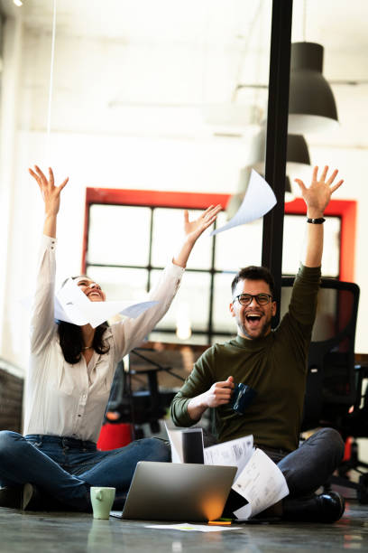istock Colleagues sitting on the floor in office. 1435264836