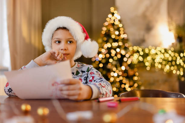 istock A black boy write letter for Santa near a festively decorated Christmas tree 1435268794