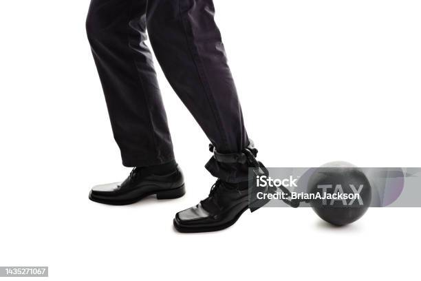 Tax Ball And Chain Restraining Businessman As He Tries To Walk Concept For Business Financial Burden Taxes And Bankruptcy Stock Photo - Download Image Now