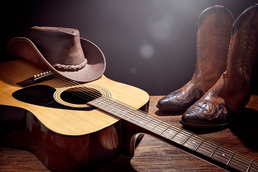 Concierto en vivo del festival de música country con guitarra acústica, sombrero de vaquero y botas photo