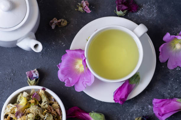 taza de té de hollyhock con flor de hollyhock seca y fresca en una mesa rústica - mallow fotografías e imágenes de stock