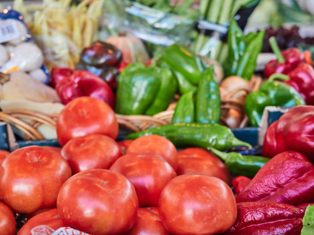 Fresh garden produce, natural tomatoes and a variety of vegetables on a stall at the food market Fresh produce from the garden, natural tomatoes and a variety of vegetables at a stall in the food market. Harvest of the day merchants gate stock pictures, royalty-free photos & images