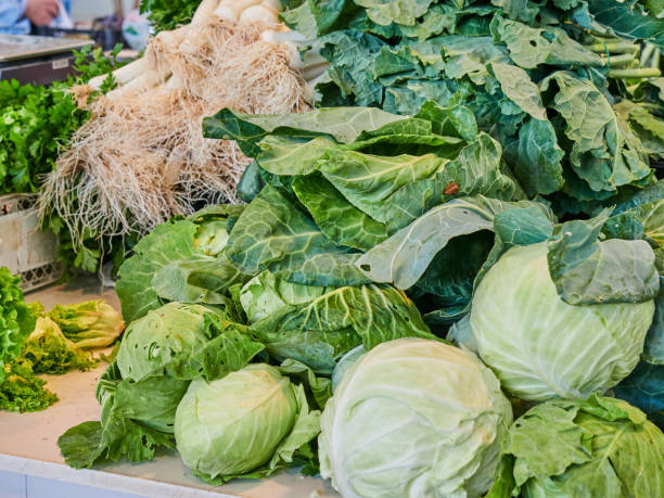 Kale, lettuce and cabbage piled up on a stall at the food market Kale, lettuce and cabbage piled up on a stall at the food market. Fresh fruit and vegetables from the garden, healthy merchants gate stock pictures, royalty-free photos & images