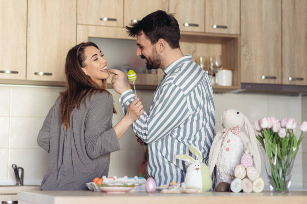 istock Attractive young man feeding his wife with Easter cookies 1435281444