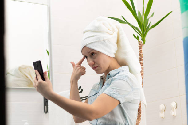 istock A young woman with a white towel on her head in a bright bathroom communicates with a smartphone with a friend in social networks. Reflection in the mirror. Selective focus 1435283654
