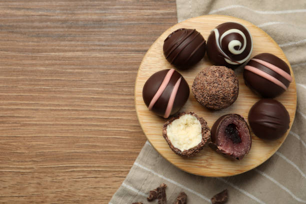 istock Many different delicious chocolate truffles on wooden table, top view. Space for text 1435284612