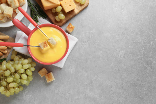 istock Flat lay composition with pot of tasty cheese fondue on grey table. Space for text 1435284622