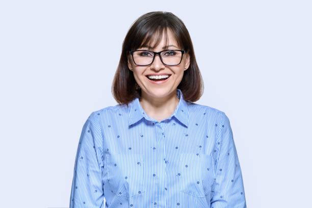 istock Middle aged smiling business woman over light background 1435285026