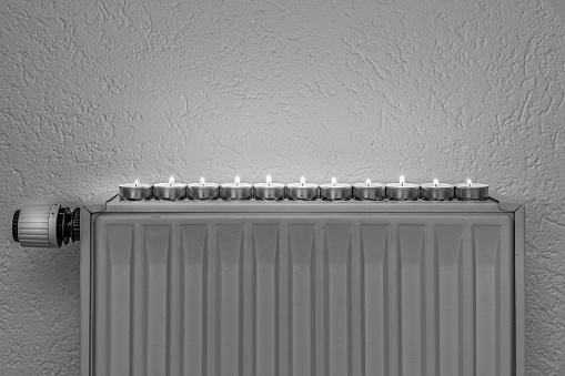 Tealights on a wall heater, concept of alternative heeating possibilities during the energy crisis and turning down the regular heating sources