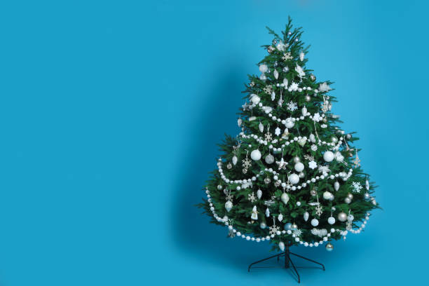 istock Beautifully decorated Christmas tree on light blue background 1435289101
