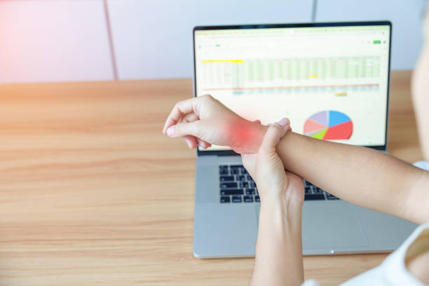 mulher que tem dor no pulso ao usar o laptop e o mouse durante o trabalho de longo tempo no local de trabalho. tenossinovite de de quervain, reumatismo ergonômico, síndrome do túnel do carpo ou conceito de síndrome do consultório - pain human muscle effort physical injury - fotografias e filmes do acervo