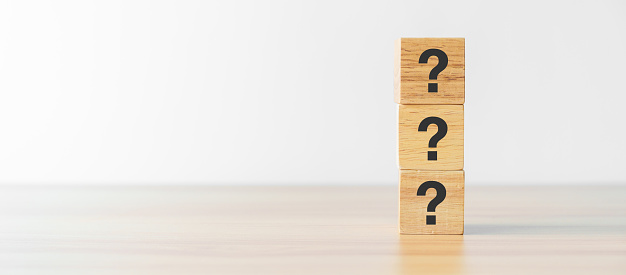 Questions Mark word with wood block on table background. FAQ, frequency asked questions, Answer, Q and A, Information, Communication, questionnaire and Brainstorming Concepts