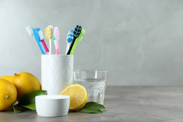 spazzolini da denti, limoni e ciotola di bicarbonato di sodio sul tavolo grigio, spazio per il testo - usare la bocca foto e immagini stock