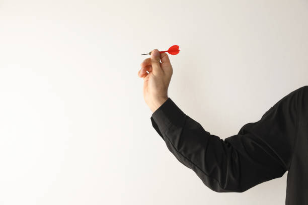 istock Man holding red dart on light background, closeup. Space for text 1435290539