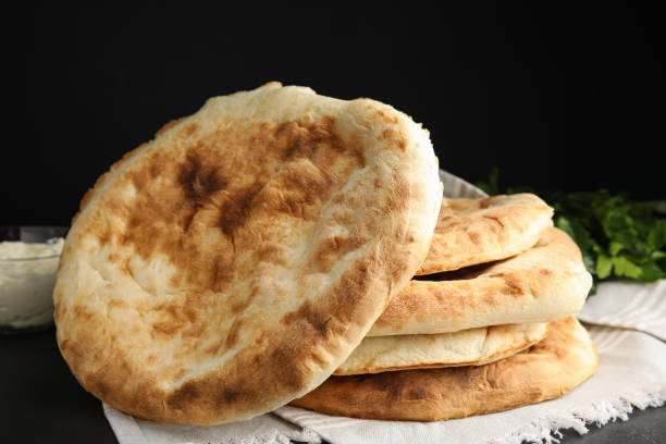 istock Delicious fresh pita bread with napkin on black table 1435291454