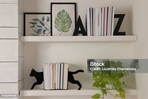 Bookends And Other Decor On Shelves Indoors Interior Design Stock Photo - Download Image Now