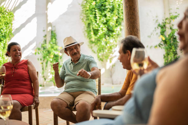 istock Group of senior friends talking while drinking wine in the backyard at home 1435291765