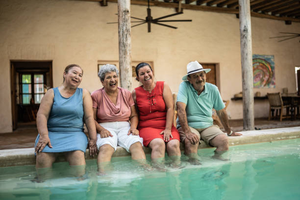 istock Senior friends having fun sitting by the pool 1435292956