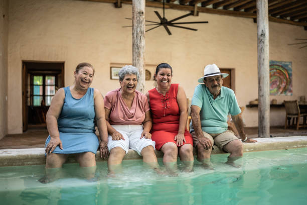 istock Senior friends having fun sitting by the pool 1435292958